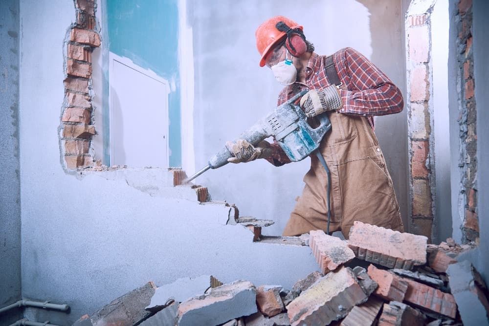 obrero desmantelando pared 